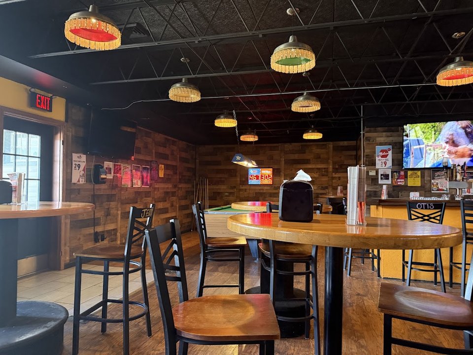 Outdoor seating beside a lively restaurant entrance.